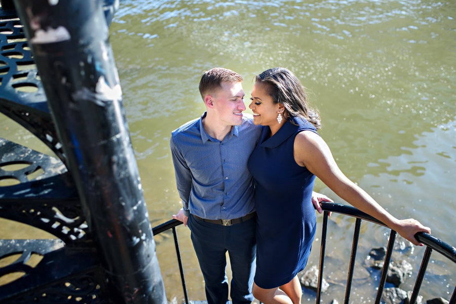 An engaged couple stop for a kiss on a wynding staircase to the Schuylkill River Trail.